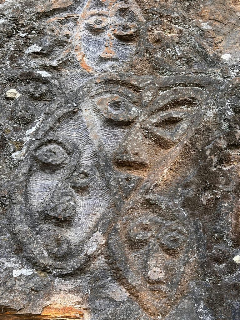 Volti scolpiti a bassorilievo su un masso del Monte Serra